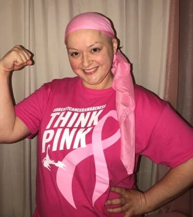 Woman in breast cancer pink shirt and wearing a headscarf